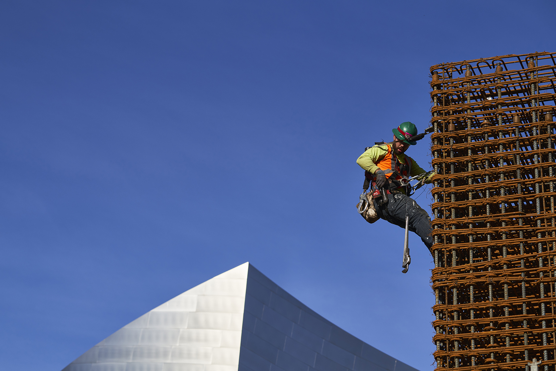 Man with Green Hardhat, Working from Staging at Construction Site