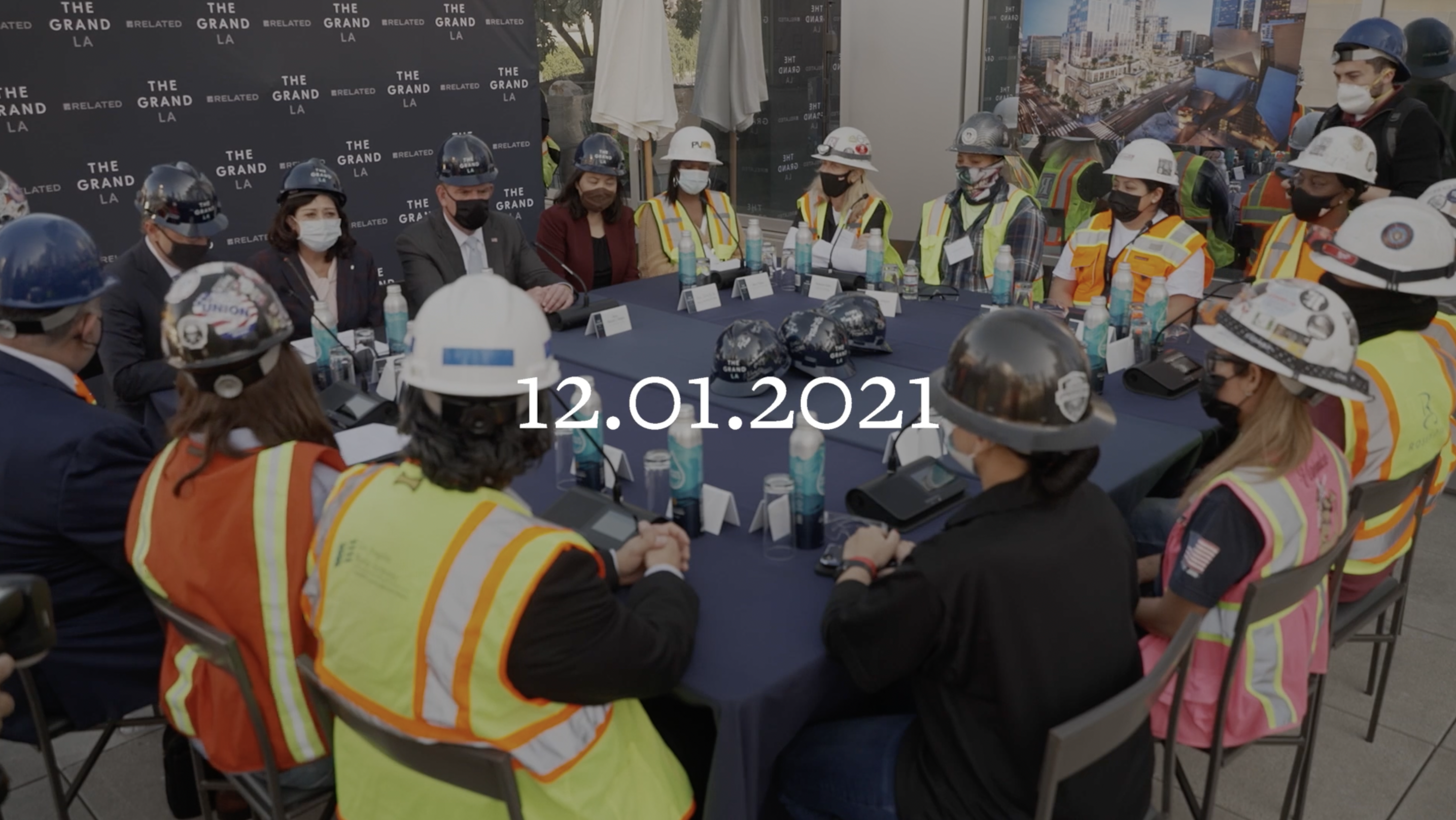 Large Table of Executives and Construction Workers with Hard Hats and Vests